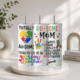 Three vertical stainless steel tumblers with colorful puzzle piece designs and text supporting autism awareness, featuring the phrase Proud Au-some Mom Tumbler – Austism Awareness Colorful Puzzle Drinkware.